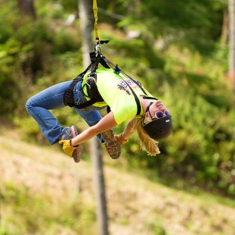 Haley grabs her feet as she zip lines