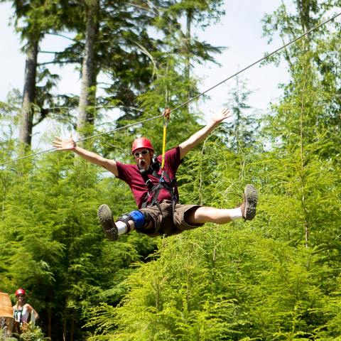 A man zip-lining over the Oregon wilderness