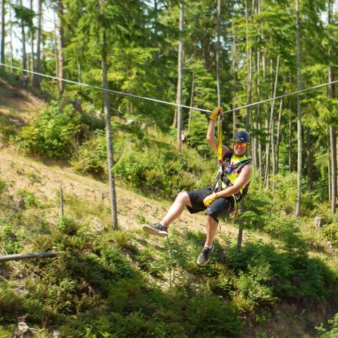 A man ziplining in the Oregon forest