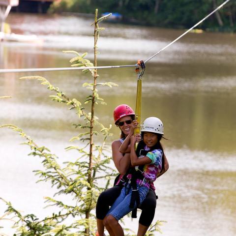 A woman and girl zipline together with High Life Adventures