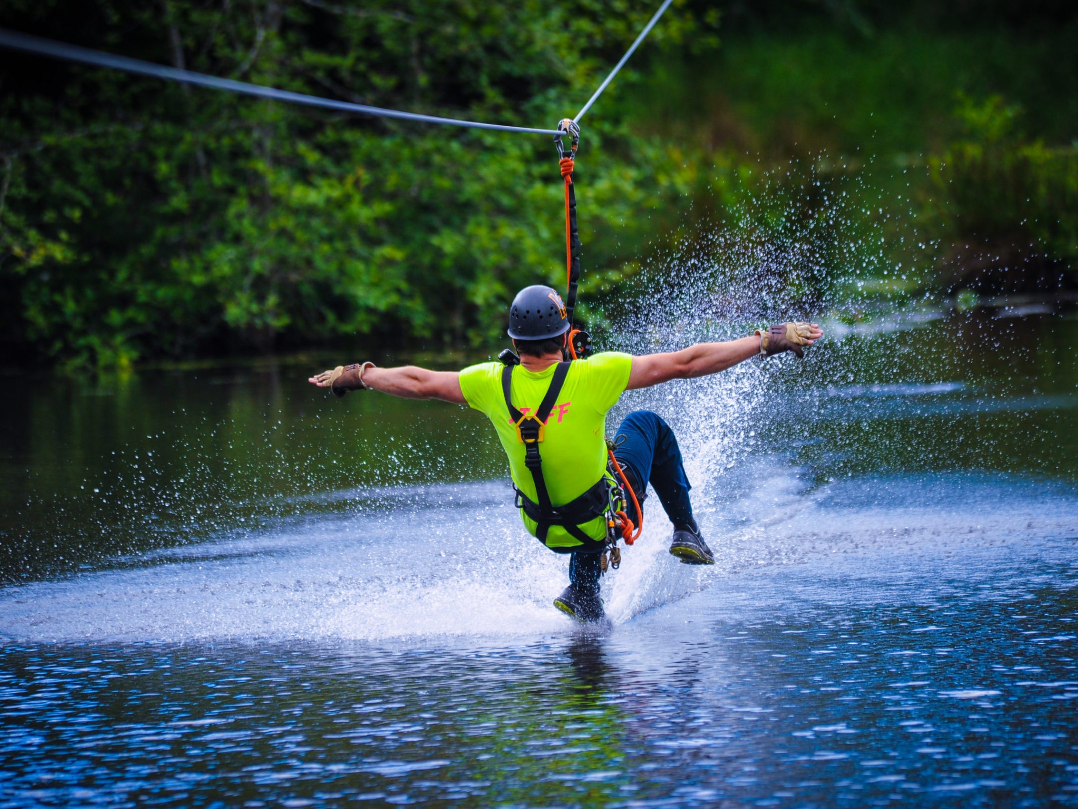 man ziplining over water