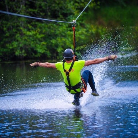 man ziplining over water