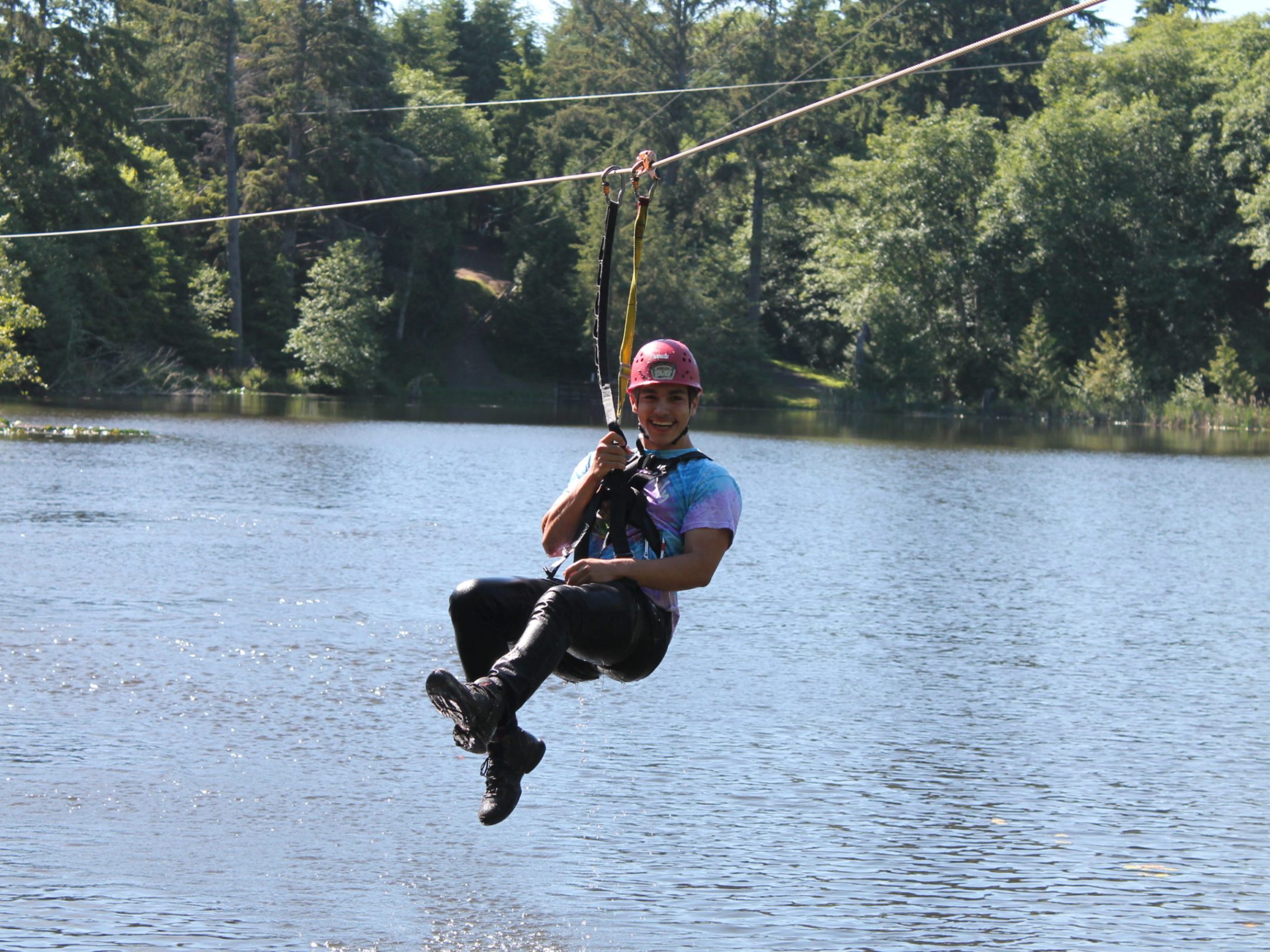 a man jumping in the air in front of a lake